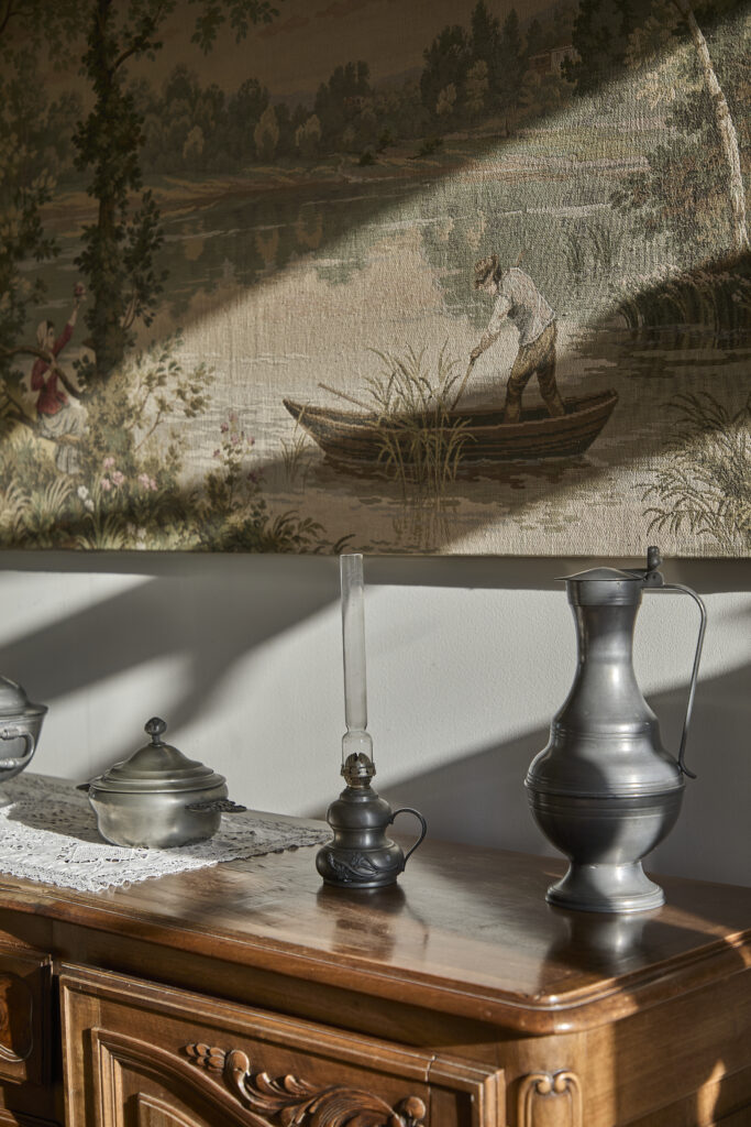 Objets sur meuble devant une tapisserie en Charente-Maritime.